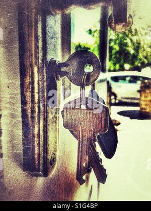 Haustür-Schlüssel in eine offene Tür Stockfoto