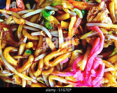 Verrühren Sie gebratenes Huhn mit Udon-Nudeln und eingelegtem Ingwer. Stockfoto