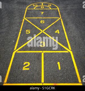 Ein Himmel und Hölle-Board auf einer Zement-Spielplatz in gelb lackiert Stockfoto