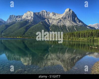 Frühen Nachmittag Blick auf Ha Ling Peak spiegelt sich in einem nahe gelegenen See in Canmore, Alberta, Kanada. Stockfoto