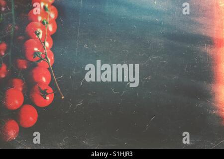 Cherry-Tomaten flach lag auf eine dunkle Steinplatte mit Exemplar Stockfoto