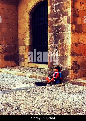 Kleiner Junge spielt Akkordeon am Tor zur Altstadt von Rhodos Stockfoto