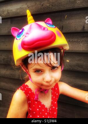 Mädchen tragen Einhorn Fahrradhelm Stockfoto