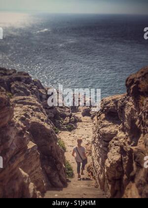 Frau hinunter Treppe vor Meerblick von Klippen in Peniche, Portugal. Stockfoto