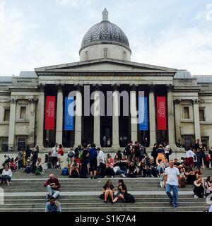 Leute sitzen auf den Stufen der national Gallery in Trafalgar Square in London, uk Stockfoto