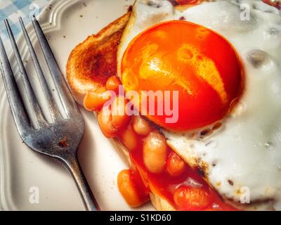 Gebackene Bohnen auf Toast mit Spiegelei Stockfoto