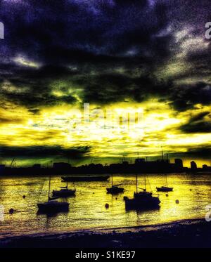 Fluss Themse romantischen Sonnenuntergang mit festgemachten Boote und dramatischer Himmel, Greenwich Peninsula, London, England Stockfoto