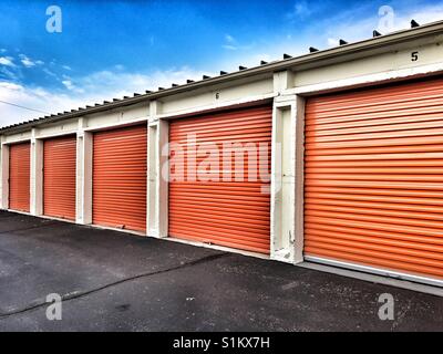 Reihe von einem orangefarbenen Metalltüren der öffentlichen Lagerhaltung Stockfoto