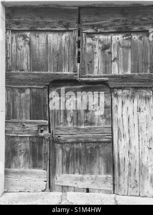 Alten rustikalen Bauernhof / stall Tür von verblassten alten Holz/Holz. In schwarz-weiß. Stockfoto