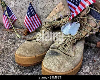 Die Erinnerung an diejenigen, die in der Wehrpflicht in den Vereinigten Staaten von Amerika gestorben sind. Alaska Memorial. Abgenutzte Militärstiefel mit Dog Tags und amerikanische Flaggen Symbolik verloren und das Opfer. Stockfoto