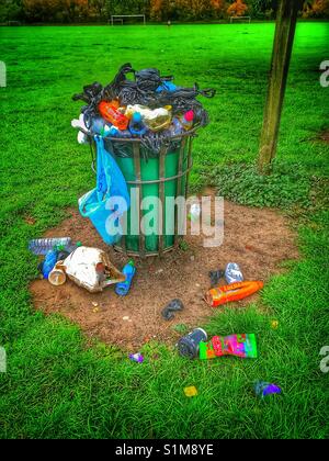 Mülleimer in einem lokalen Park, der voller Abfall Stockfoto