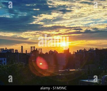 Lens flare Sonnenuntergang von Lower Manhattan von einem Fenster in Williamsburg, Brooklyn. Stockfoto