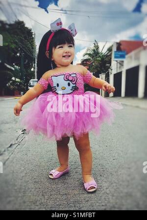 Süße kleine angele91 trägt einen rosa hello kitty Tutu Kleid und rosa Mini Puppe Schuhe. Stockfoto
