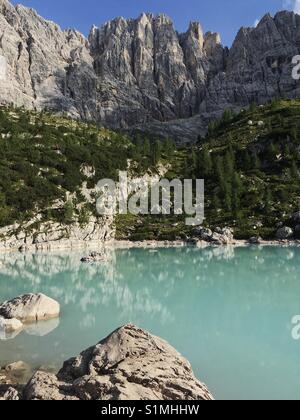 Sonnigen Sommertag auf eine Wanderung zum Lake Sorapis in Italien, in den Dolomiten, zu einem Blick auf türkisblaues Wasser und scharfen Bergspitzen der Dolomiten begeistert Stockfoto