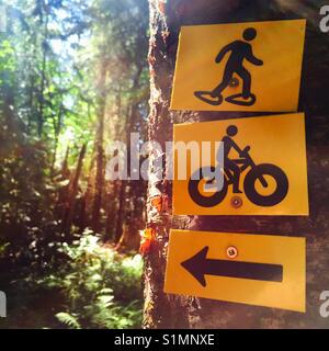 Schilder an einem Baum, der auf die Schneeschuh- und Radwege Stockfoto