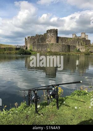 Angeln ist ein Angler am Ufer des Wassergrabens von Caerphilly Castle Stockfoto