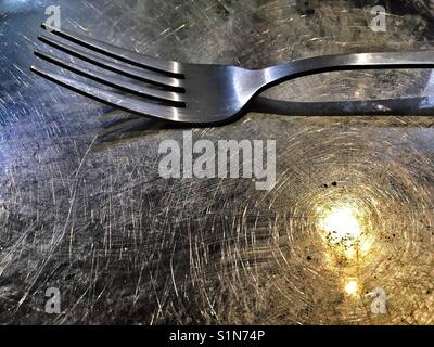 Edelstahl Gabel auf einer Platte aus rostfreiem Stahl. Stockfoto