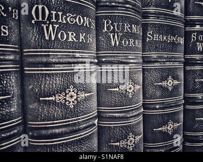 Alte ledergebundene Bücher, darunter die Werke von Milton, Burns und Shakespeare Stockfoto