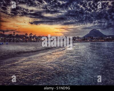 Sonnenuntergang über dem Strand Arenal mit Montgo Berg hinter, in Javea an der Costa Blanca, Spanien Stockfoto