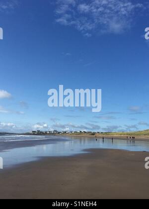 Wanderer am späten Nachmittag im September auf breiter Strand, Rhosneigr, Anglesey, Nordwales Stockfoto