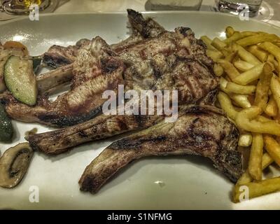 Gegrillte Lammkoteletts und Chips, typisch spanisches Essen Stockfoto