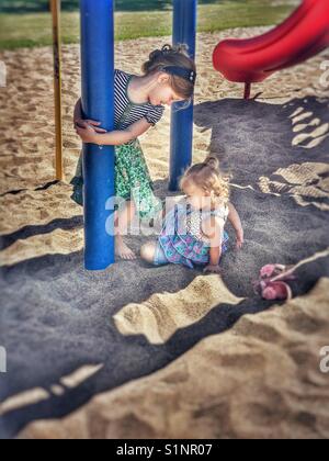 Schwestern spielen im Park im Sand Stockfoto