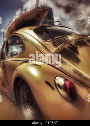 Gelber Vintage Volkswagen Käfer mit Surfbrettständer Stockfoto
