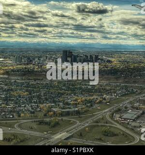 Kern der Innenstadt der Stadt Calgary, mit felsigen Bergen im Hintergrund, wie man es von einem Flugzeug über das Land gesehen. Alberta, Kanada. Stockfoto