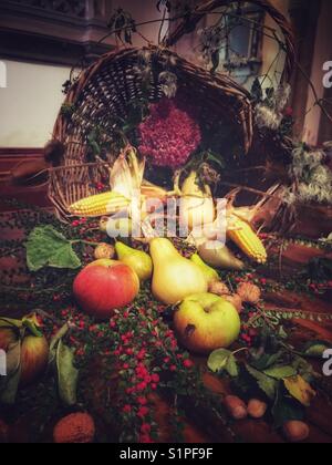 Blumen- und Obstarrangements in einer Kirche, die für das Erntefest dekoriert ist. Stockfoto