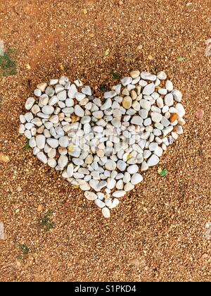 Herz mit kleinen weißen Steinen Stockfoto