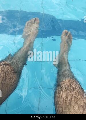 Die Beine des Mannes in einem Schwimmbad Stockfoto