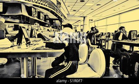 Passagiere auf elektronische Geräte an der Toronto Pearson International Airport, Toronto, Ontario, Kanada Stockfoto