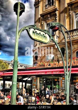 Zeichen für Pariser Metrostation vor Cafe Stockfoto