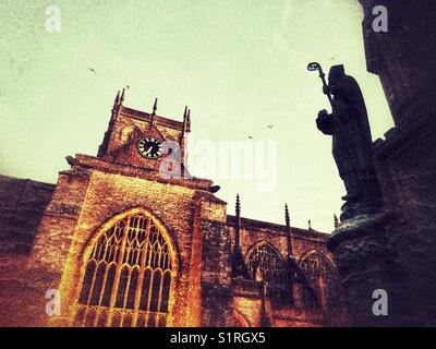 Sherborne Abbey, mit Flutlicht in der Morgendämmerung, Digby Memorial im Vordergrund. Sherbourne, Dorset, England Stockfoto