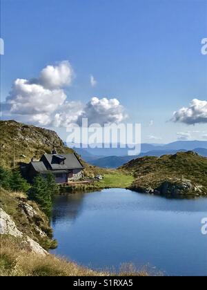 Eine schöne Hütte in der Nähe von einem See auf dem Gipfel eines Berges in Bergen Morway Stockfoto