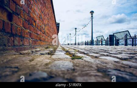 Die Waterfront gepflasterten Weg, der entlang der Uferpromenade am Albert Dock Liverpool läuft Stockfoto