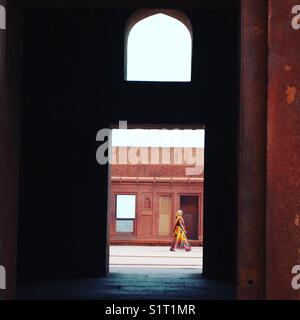 Frau in einem Sari durch einen Torbogen an der Amer Fort, Rajasthan, Jaipur, Indien Stockfoto