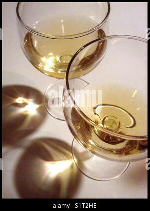 Eine Probe von „Orangenwein“ (Vorderseite) aus [weißen] Macabeo-Trauben, die auf den Schalen fermentiert wurden (mit dem normalen Gegenstück im Glas hinten), Katalonien, Spanien. Stockfoto
