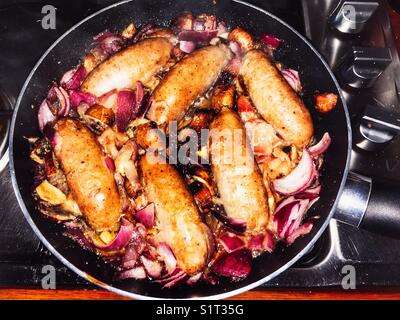 Gebratene Würstchen, roten Zwiebeln, Champignons und Speck. Stockfoto