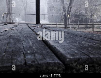 Abgenutzter Picknicktisch im Herbstnebel Stockfoto