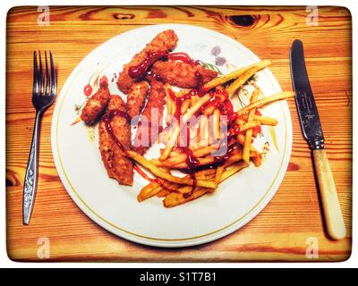 Rotzunge Hühnerfiletstreifen paniert mit Pommes mit Ketchup Stockfoto