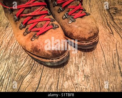 Ein paar alte Wanderschuhe mit roten Schnürsenkeln Stockfoto