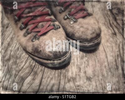 Ein paar alte Wanderschuhe mit roten Schnürsenkeln Stockfoto