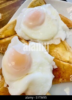 Pochierte Eier auf Toast weiß Stockfoto