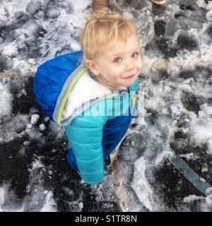 Ein Jahr alten Baby boy in einem Schnee Anzug schauen in die Kamera. Stockfoto