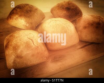 Frisch gebackene Brötchen auf ein Holzbrett. Stockfoto