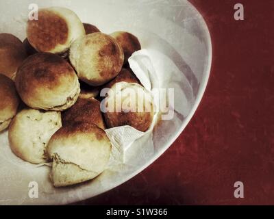 Frisch gebackene Abendessen Brötchen auf weiße Platte rot Tischdecke Stockfoto