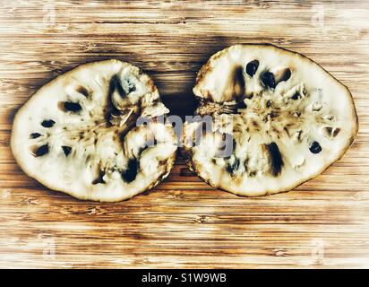 Cherimoya, auch bekannt als Cherimoya, Sweetsop, Zucker - apple, Annona squamosa, halbiert. Stockfoto