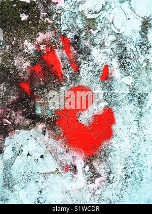 Ein zartes rotes Handmuster auf einer grungigen Wand Stockfoto