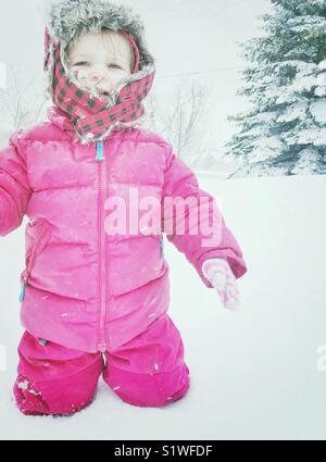 Kleinkind stehendes Mädchen in tiefem Schnee gebündelt in schneeanzug Schreien Stockfoto